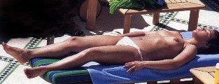Séverine Ferrer nude in topless sunbathing
